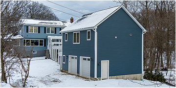 Detached blue dwelling beside an existing home.